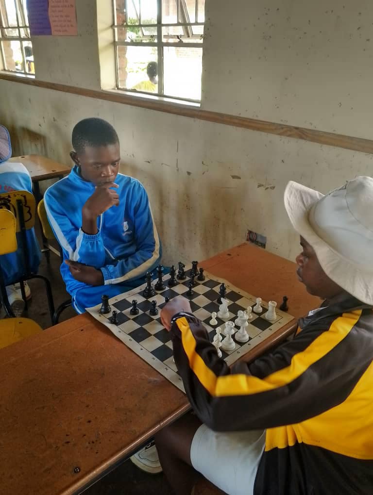 Two pupils deep in concentration over a chess match